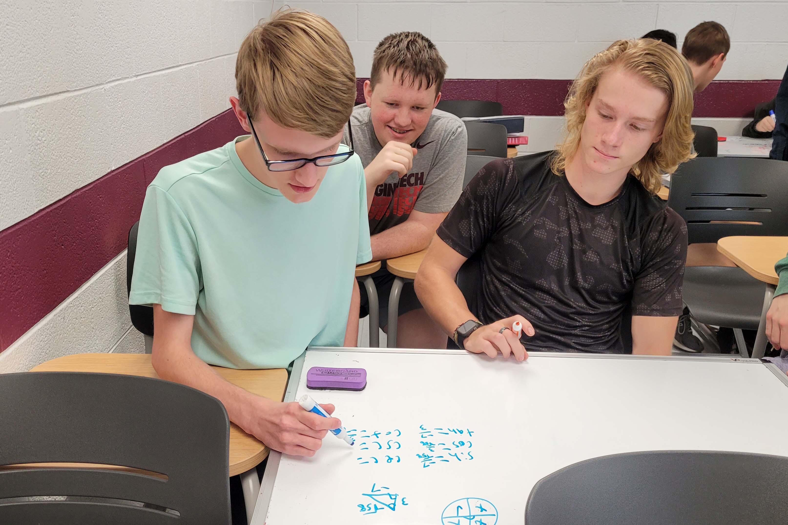 Students solve problems together on whiteboards in Precalculus with Trigonometry.